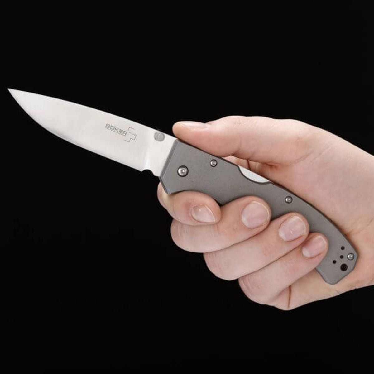 Böker Plus Titan Drop – Taschenmesser mit Droppoint-Klinge und Titangriffschalen. Größenvergleich des Taschenmessers in der Hand.