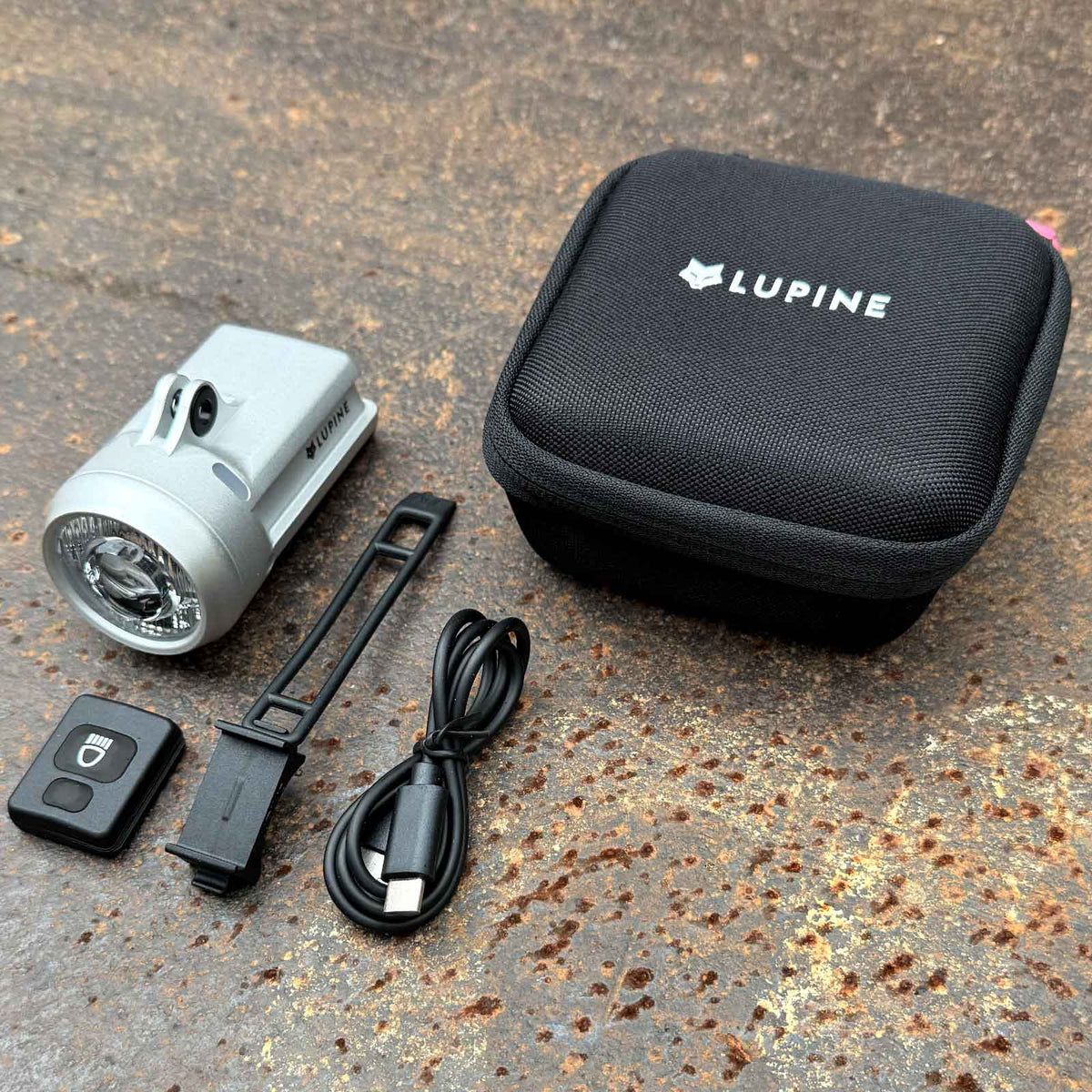 Lupine SL Grano F Silver Edition – StVZO-Frontlicht, 1100 Lumen und Fernlicht. Übersicht des Kartoninhalts mit Fahrradlampe und Zubehör.