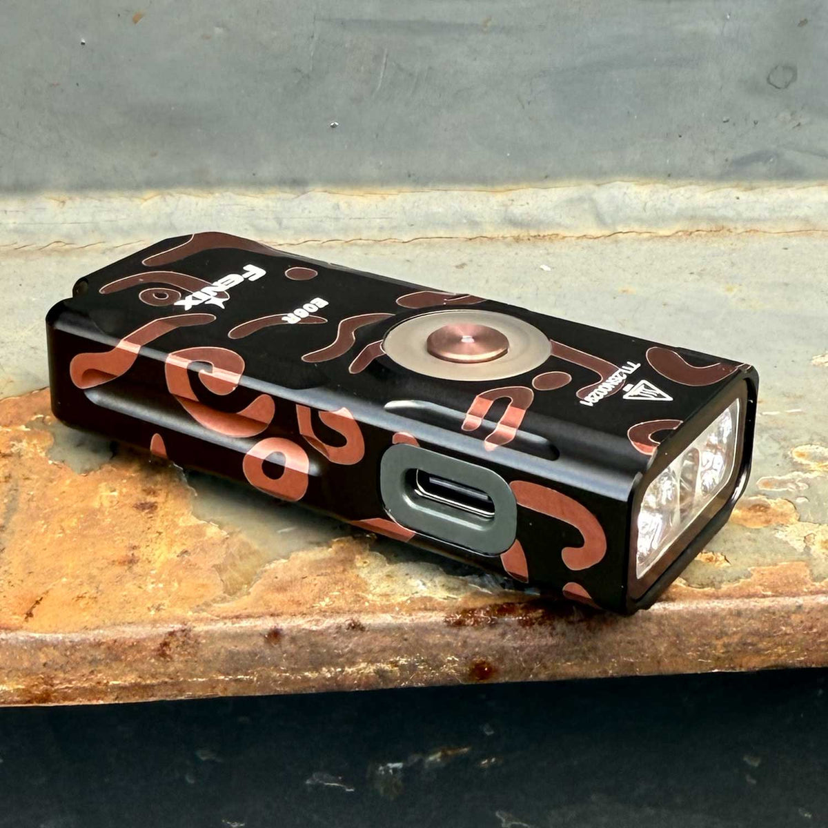 Fenix E06R – Schlüsselbundlampe mit 700 Lumen, UV-Licht und rotem Laser. Graffiti-Ausführung mit integriertem Akku und USB-C-Ladeanschluss.