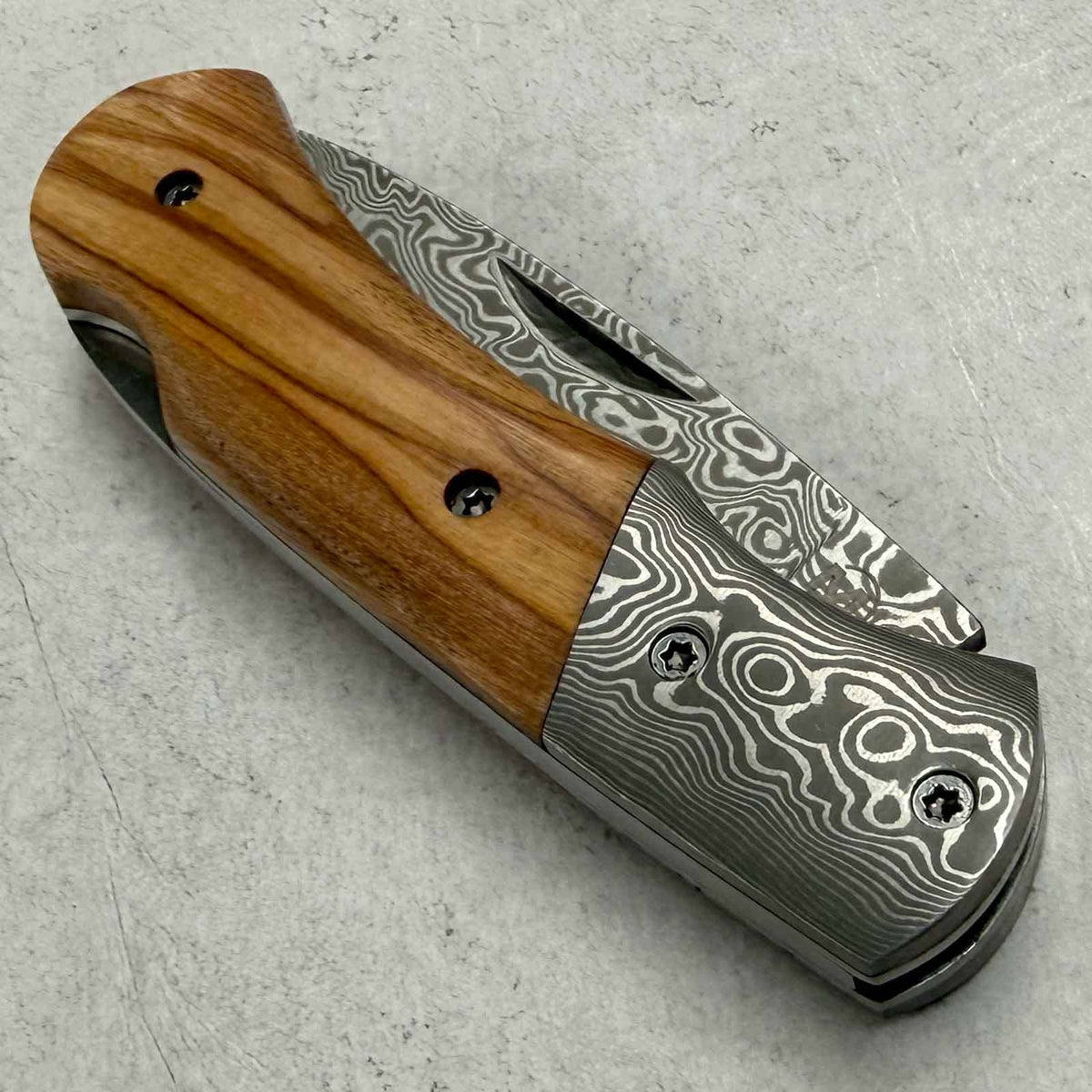 Magnum Damascus Mistress – elegantes Damast-Taschenmesser mit Olivenholzgriff. Ansicht des Taschenmessers für den Alltag mit Damastklinge und Holzgriff.
