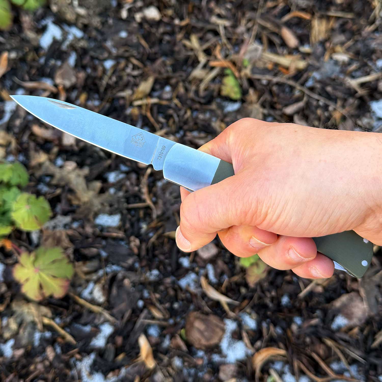 Puma TEC Jagdtaschenmesser mit Säge und Aufbrechklinge inkl. Lederetui – Farbvariante grün, Größenvergleich in der Hand